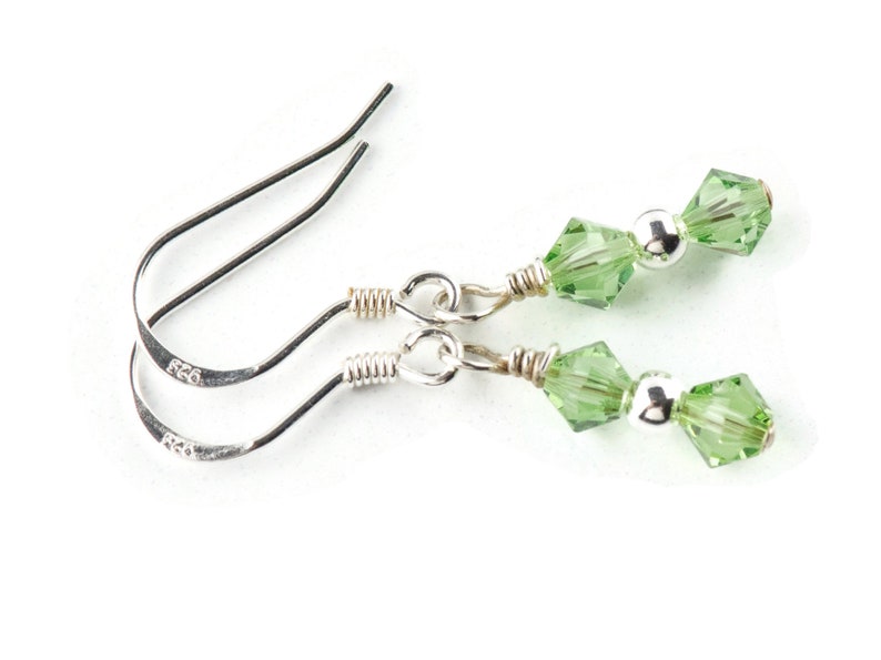 May include: A pair of silver dangle earrings with green crystal beads.