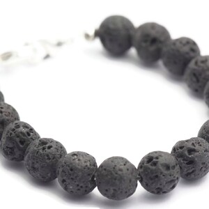 May include: A black lava rock beaded bracelet with a silver clasp.