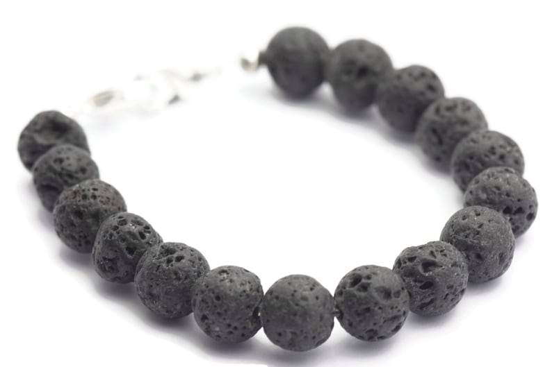 May include: A black lava rock beaded bracelet with a silver clasp.