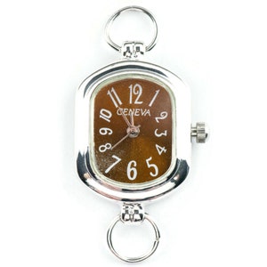 May include: Silver Geneva watch with a rectangular face and a brown dial. The watch has white numerals and hands, and two silver rings for attachment. A classic accessory.