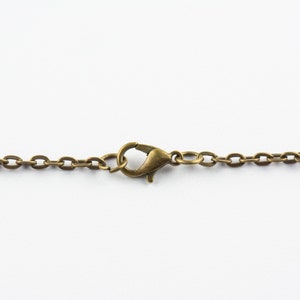 May include: A close-up of a gold-toned chain with a lobster clasp.