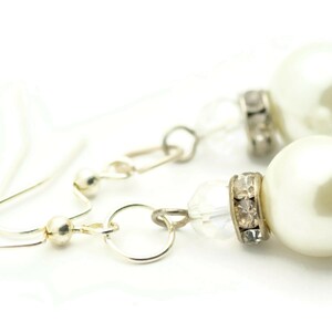 Peut inclure: Une paire de boucles d'oreilles en argent avec des accents de perles blanches et de cristal.