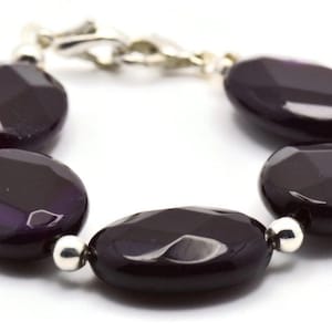 May include: A purple agate gemstone bracelet with silver beads and a silver clasp.