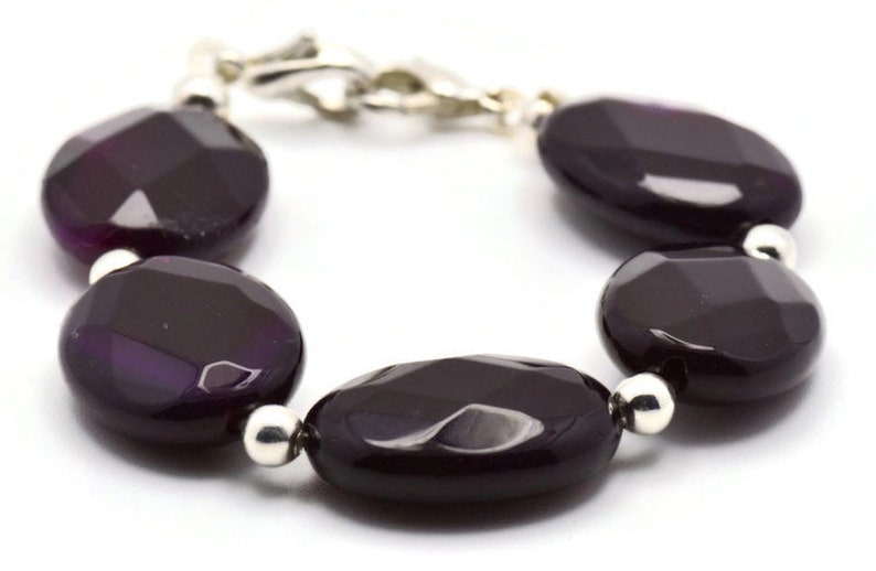 May include: A purple agate gemstone bracelet with silver beads and a silver clasp.