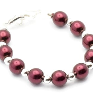 May include: A burgundy pearl bracelet with silver beads and a silver clasp.