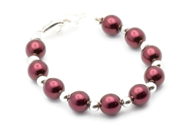 May include: A burgundy pearl bracelet with silver beads and a silver clasp.