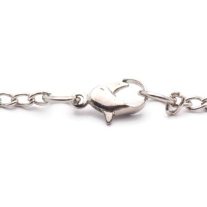May include: A silver chain necklace with a lobster claw clasp.
