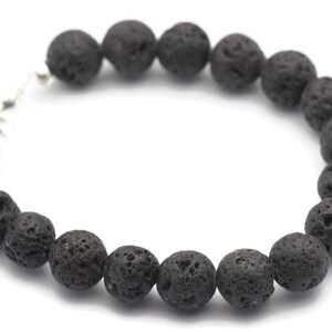 May include: A black lava rock beaded bracelet with a silver clasp.