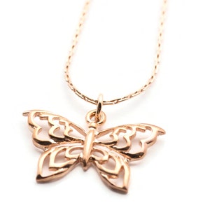 Peut inclure: Un collier d&eacute;licat en cha&icirc;ne dor&eacute;e avec un pendentif papillon d&eacute;taill&eacute;. Le papillon est en m&eacute;tal ajour&eacute; et pr&eacute;sente un design d&eacute;licat et f&eacute;minin.