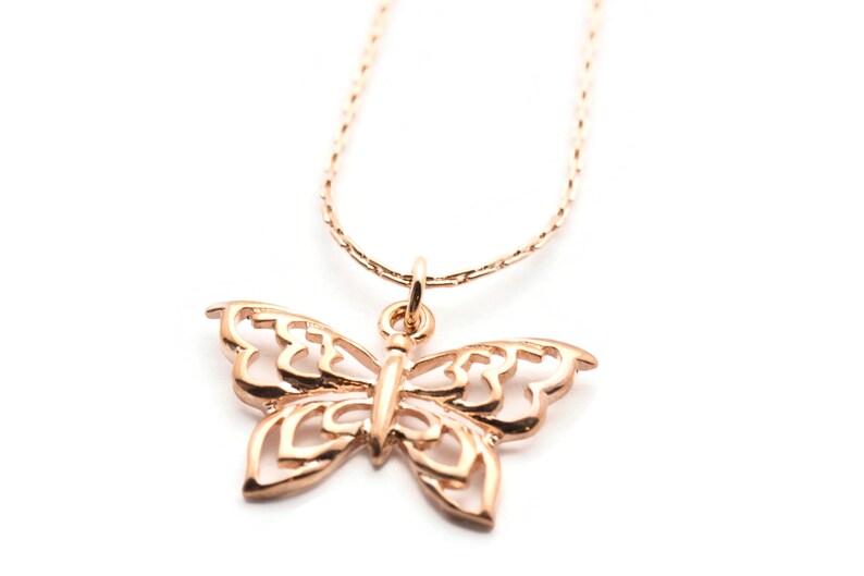 Peut inclure: Un collier d&eacute;licat en cha&icirc;ne dor&eacute;e avec un pendentif papillon d&eacute;taill&eacute;. Le papillon est en m&eacute;tal ajour&eacute; et pr&eacute;sente un design d&eacute;licat et f&eacute;minin.