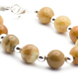 May include: A brown and white gemstone bracelet with silver beads and a silver clasp.