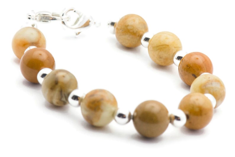 May include: A brown and white gemstone bracelet with silver beads and a silver clasp.