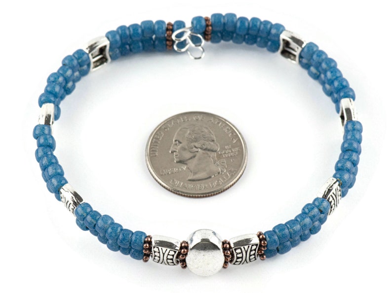 Button and Bows French Blue Cuff Memory Wire Bracelet on a white background. Quarter in center of bracelet is for a size reference.