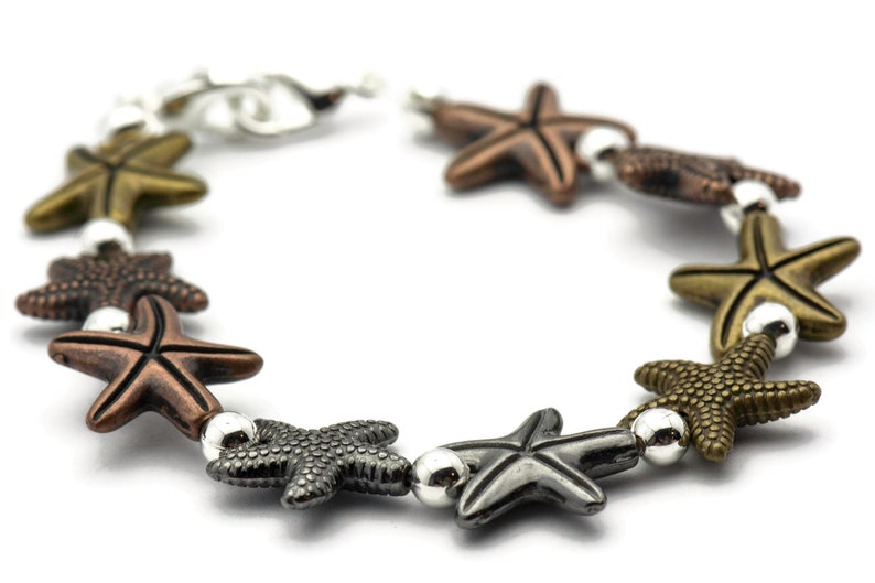 May include: A silver and bronze bracelet with a series of starfish charms. The bracelet is made of metal and has a clasp closure.