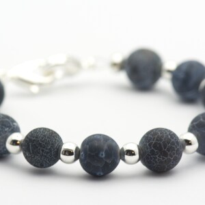 May include: A dark blue agate beaded bracelet with silver spacer beads. The bracelet has a silver clasp.