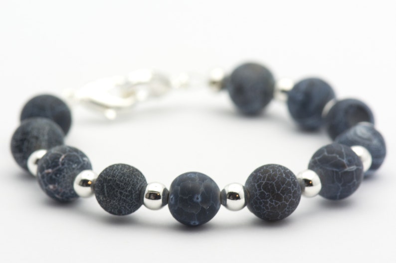 May include: A dark blue agate beaded bracelet with silver spacer beads. The bracelet has a silver clasp.