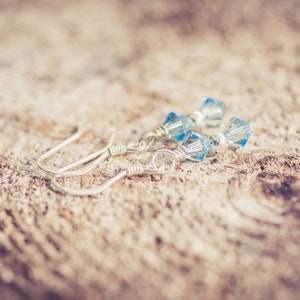 March Aquamarine Swarovski Crystal Birth Month Sterling Silver Drop Earrings on wood background
