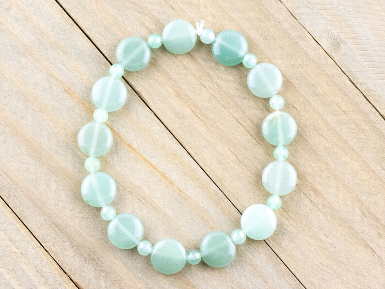 Peut inclure: Un bracelet en perles vert clair avec des perles rondes. Le bracelet est fait de pierre naturelle et est enfil&eacute; sur un cordon &eacute;lastique transparent.