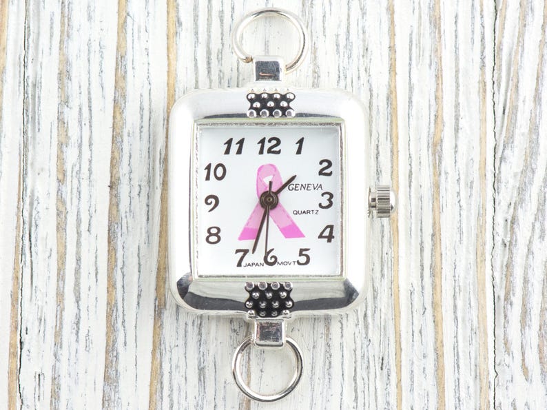 Pu&ograve; includere: Orologio al quarzo quadrato color argento con quadrante bianco con numeri neri e un nastro rosa. L'orologio ha anelli nella parte superiore e inferiore per il fissaggio. Il quadrante recita "GENEVA QUARTZ JAPAN MOV'T".