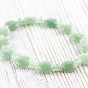 Peut inclure: Un bracelet en pierres pr&eacute;cieuses vertes avec des perles de forme ovale. Le bracelet est fait de pierres naturelles et est un bel accessoire pour toutes les occasions.