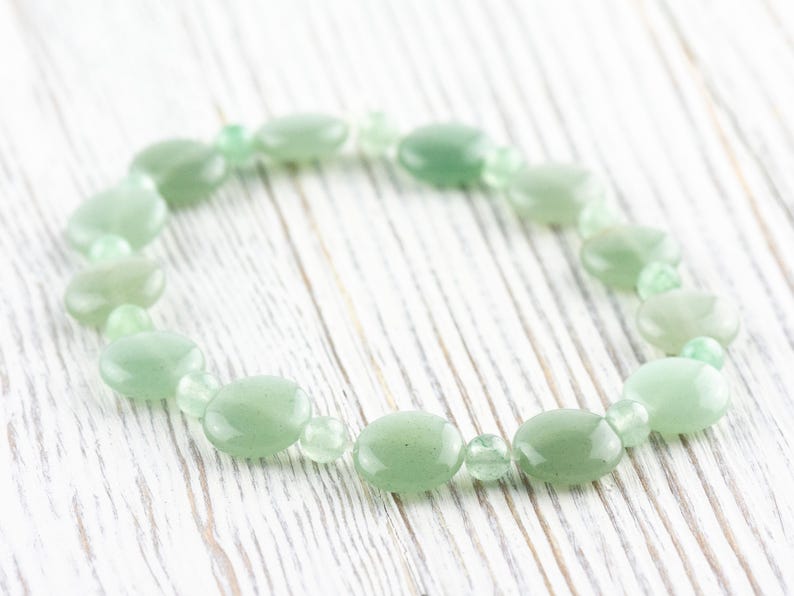 Peut inclure: Un bracelet en pierres pr&eacute;cieuses vertes avec des perles de forme ovale. Le bracelet est fait de pierres naturelles et est un bel accessoire pour toutes les occasions.