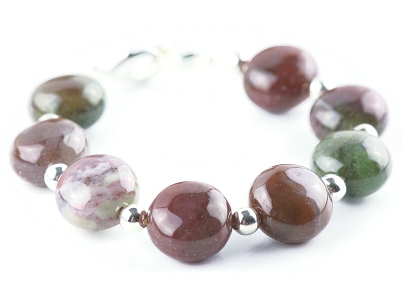 May include: A bracelet made of brown, green, and white agate beads with silver spacers.