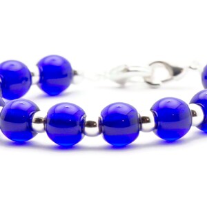 May include: A blue glass bead bracelet with silver spacers. The bracelet has a silver clasp.