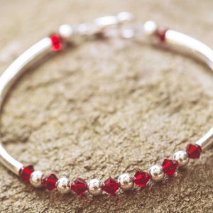 January Garnet Swarovski Crystal Birth Month Sterling Silver Plated Bracelet on stone