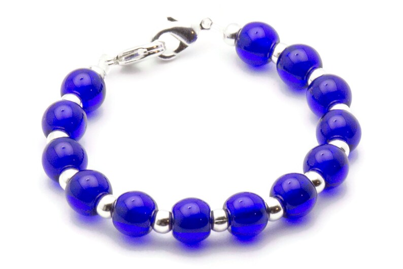 May include: A bracelet with alternating blue glass beads and silver beads. The bracelet has a silver clasp.