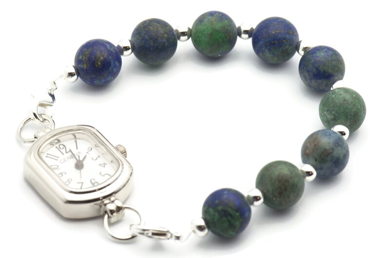 May include: A silver watch with a square face and a beaded bracelet made of blue and green stones.