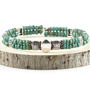 Button and Bows Desert Turquoise Cuff Memory Wire Bracelet on a wood piece with tree bark edging