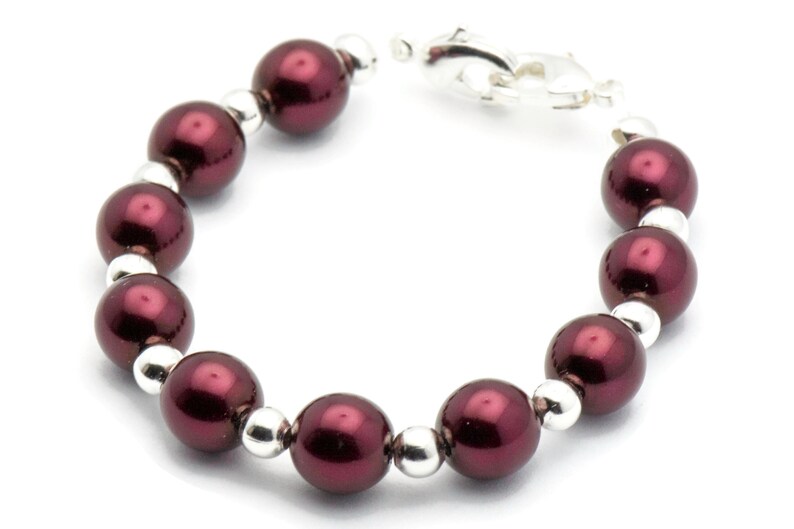 May include: A burgundy pearl bracelet with silver beads and a silver clasp.
