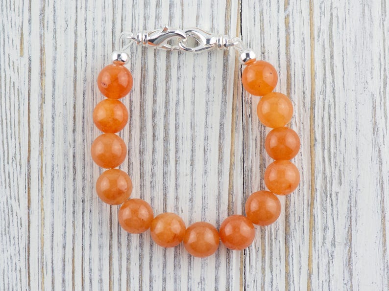 Op de afbeelding: Een armband gemaakt met oranje carneol kralen en een zilveren sluiting.