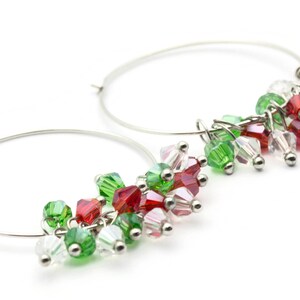 May include: Silver hoop earrings with dangling red, green, and clear crystal beads.