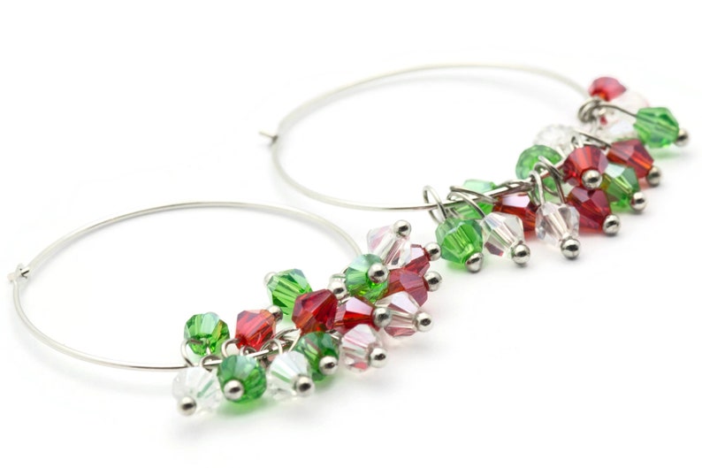 May include: Silver hoop earrings with dangling red, green, and clear crystal beads.