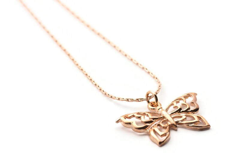 Peut inclure: Un collier d&eacute;licat en cha&icirc;ne dor&eacute;e avec un pendentif papillon d&eacute;taill&eacute;. Le papillon est fait de m&eacute;tal ajour&eacute; et pr&eacute;sente un design d&eacute;licat et complexe.