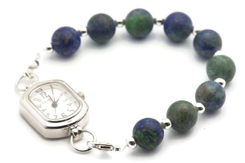 May include: A silver watch with a square face and a beaded bracelet. The beads are a mix of blue and green.