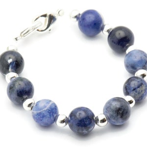 K&ouml;nnte beinhalten: Ein Armband aus blauen Edelsteinen mit silbernen Perlen und einem silbernen Verschluss.