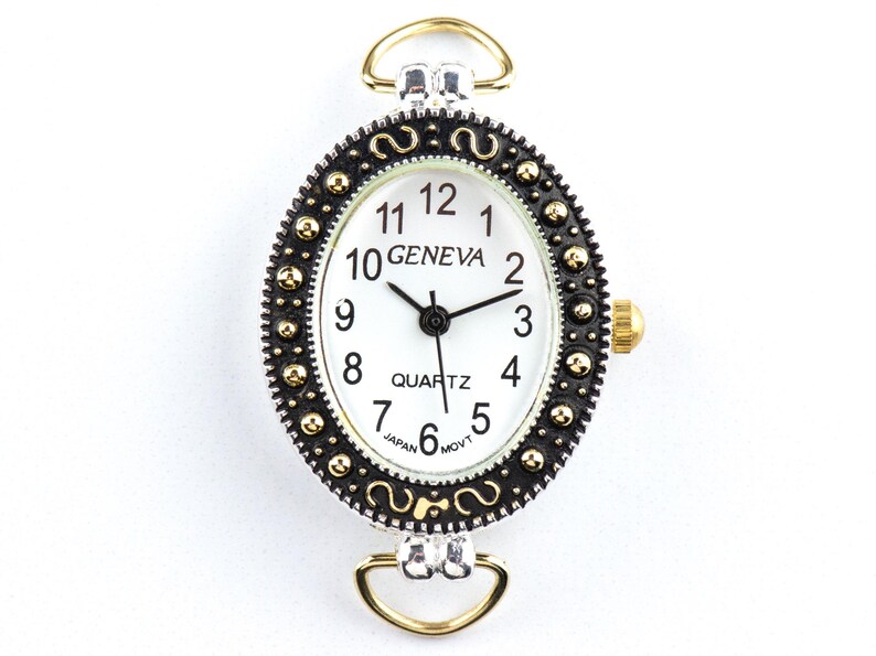 May include: Oval Geneva quartz watch with a white face, black hands, and gold-tone accents. The watch has a black and gold bezel and gold-tone loops for attachment. The watch face displays the word "GENEVA" and "QUARTZ".