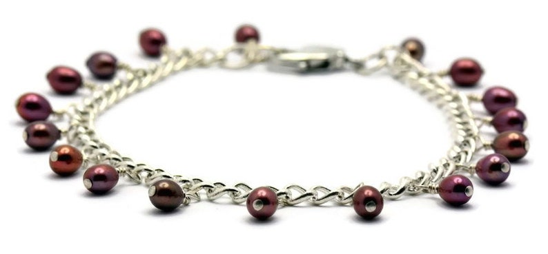 May include: A silver chain bracelet with a silver clasp and multiple dangling maroon pearls.