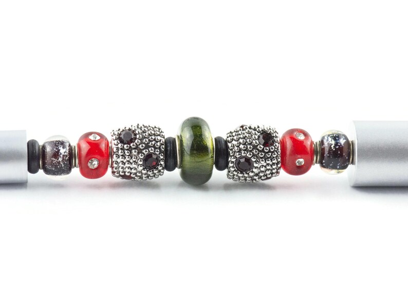 May include: A silver charm bracelet with red, green and black beads. The beads are made of glass and metal.