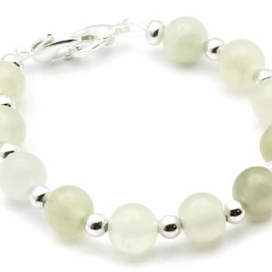 May include: A bracelet made of light green and white beads with silver accents.