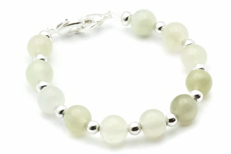 May include: A bracelet made of light green and white beads with silver accents.