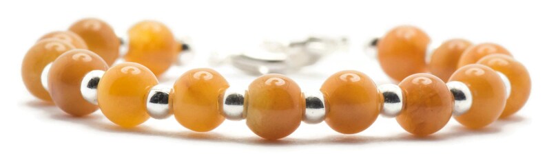 May include: A bracelet made of orange gemstone beads and silver spacer beads.