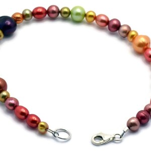 Pu&ograve; includere: Un braccialetto di perle multicolori con una chiusura argentata. Le perle sono in tonalit&agrave; di rosa, arancio, verde e oro.
