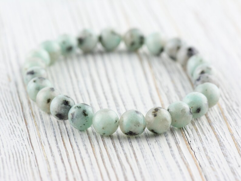Puede incluir: Un brazalete hecho de cuentas verdes y negras moteadas. El brazalete est&aacute; hecho de piedra natural y tiene aproximadamente 18 cm de largo.
