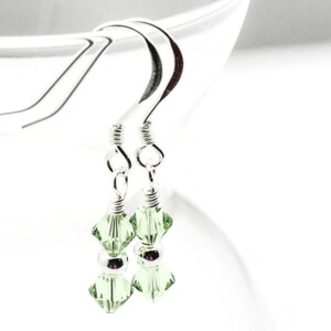 August Peridot Swarovski Crystal Birth Month Sterling Silver Drop Earrings hanging on vase