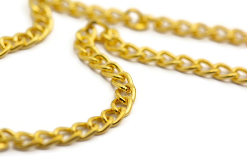 Puede incluir: Primer plano de un collar de cadena de oro. La cadena est&aacute; hecha de eslabones gruesos e interconectados.