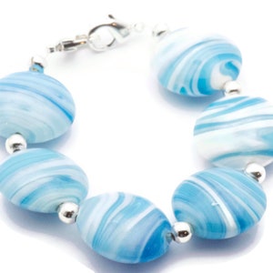May include: A bracelet made of blue and white swirled glass beads with silver accents.