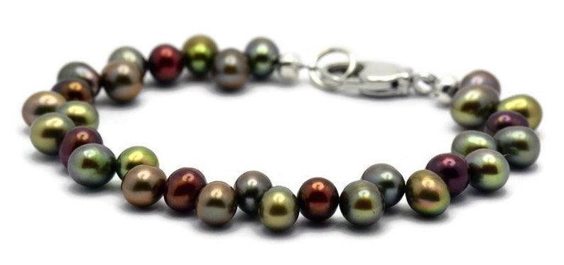Puede incluir: Un brazalete hecho de perlas de color verde oscuro, marr&oacute;n y negro con un cierre plateado.